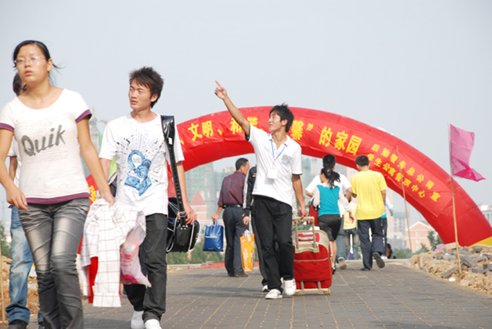 9月19日，滁州学院一名志愿者带领新生熟悉校园。当日，该校2009级学生入学报到。鲁龙摄